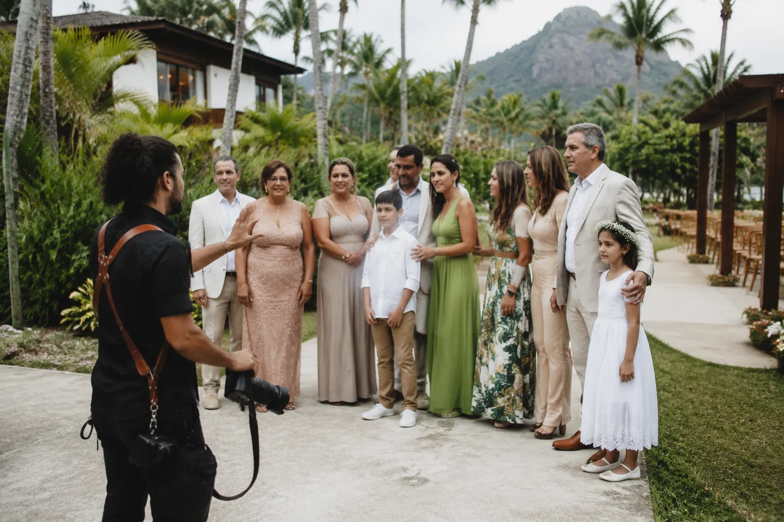 Wedding photographer organizing family portraits near a ceremony venue
